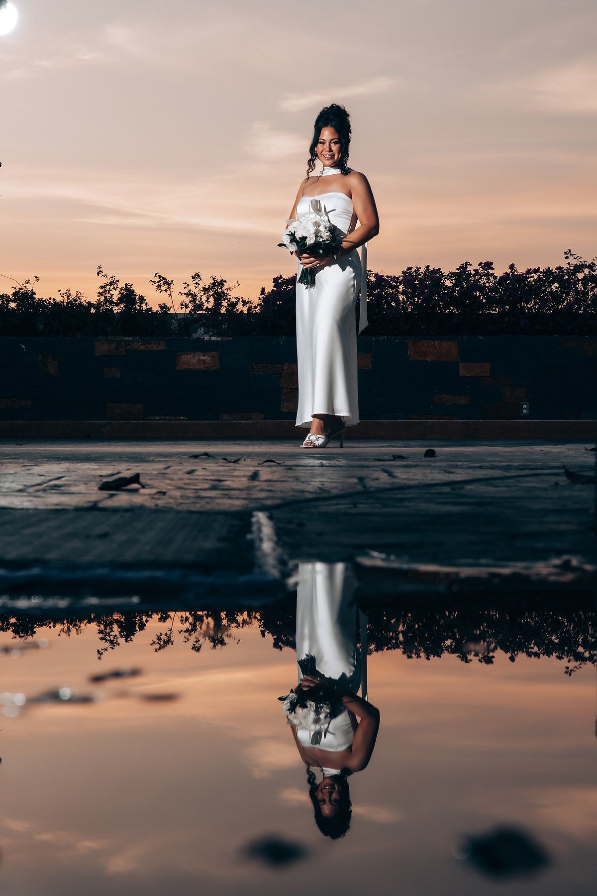 Artistic reflection photography at sunset with water puddle creating mirror effect.