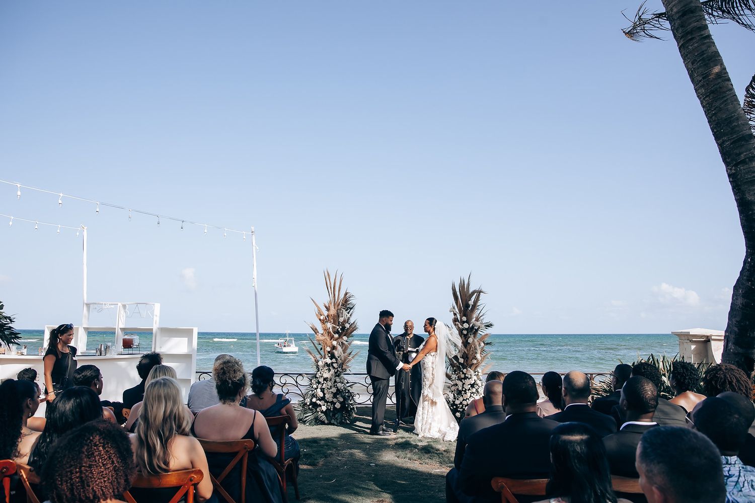 Beachside wedding ceremony with guests seated facing the ocean view.