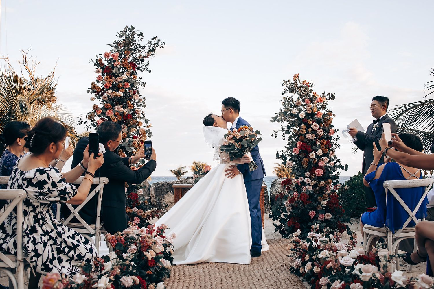 Wedding celebration with decorative floral arrangements and guests in attendance.