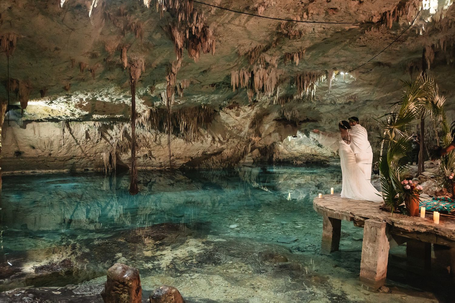 Underground cave cenote with crystal clear turquoise waters and stalactites.