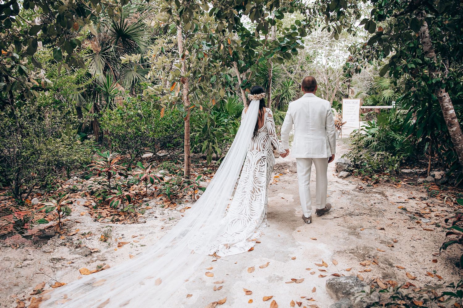 A scenic forest path leads to a white wedding dress train flowing elegantly through the natural surroundings.