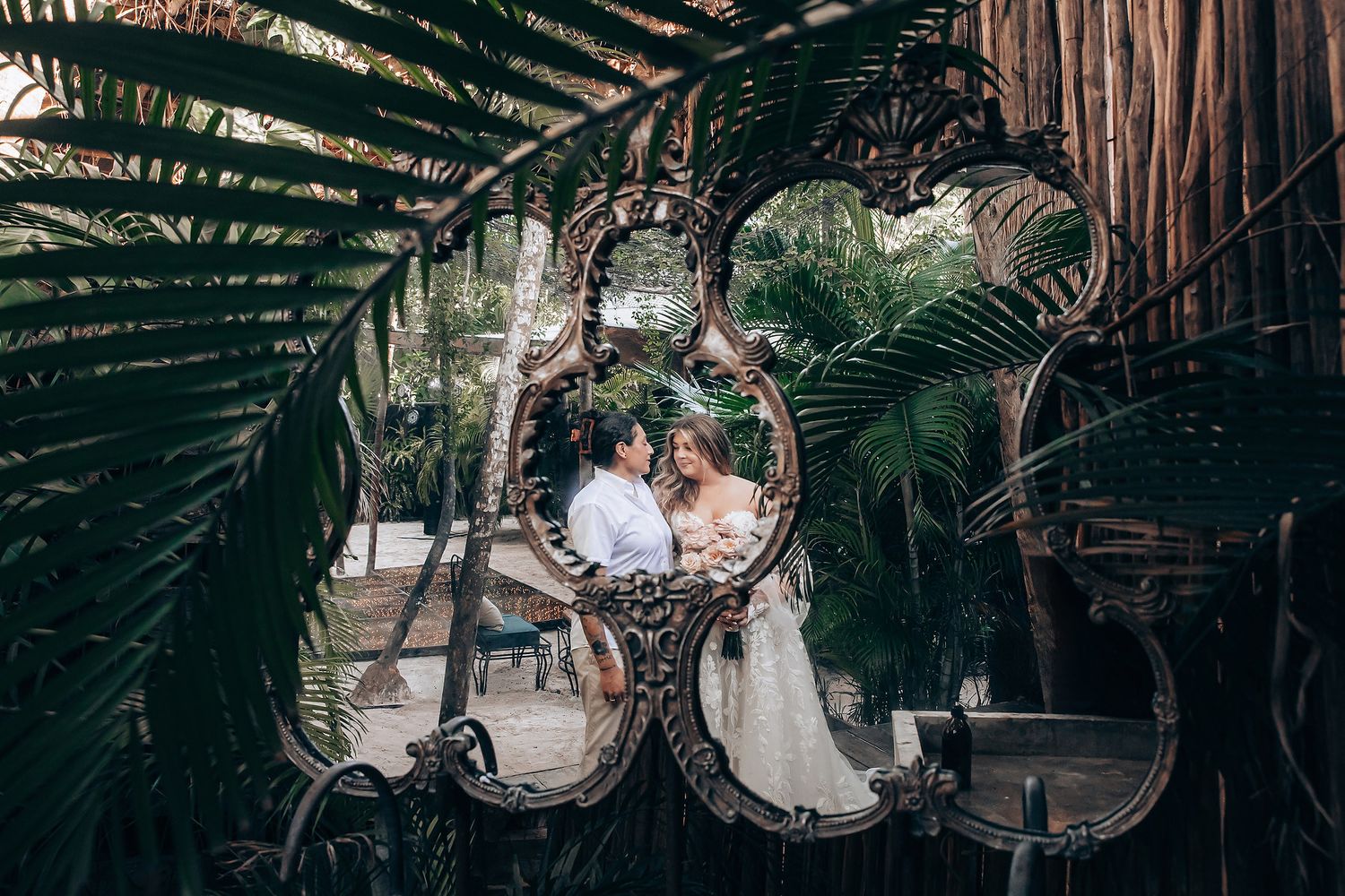Lush tropical garden setting with palm fronds and wooden structures creating a natural archway.