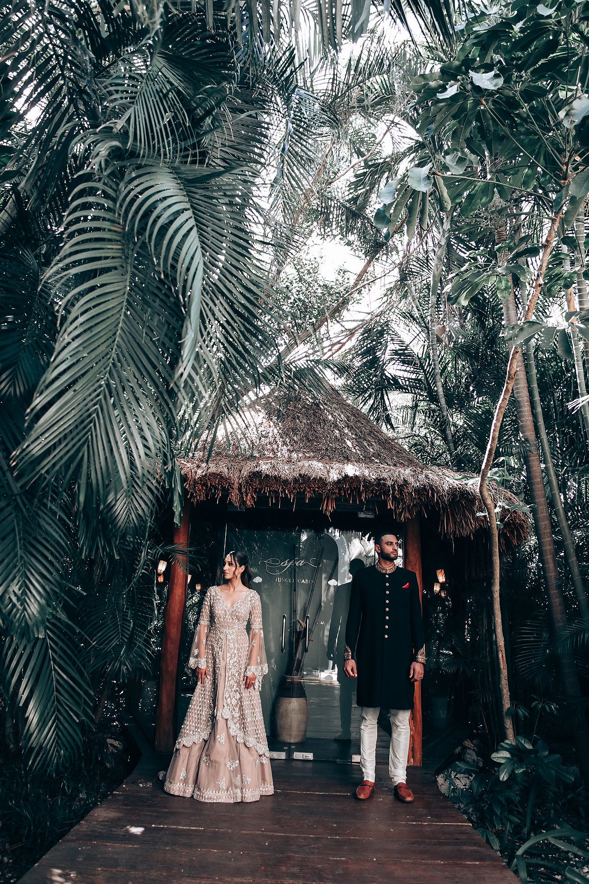 Wedding ceremony space with thatched roof gazebo and tropical landscaping.