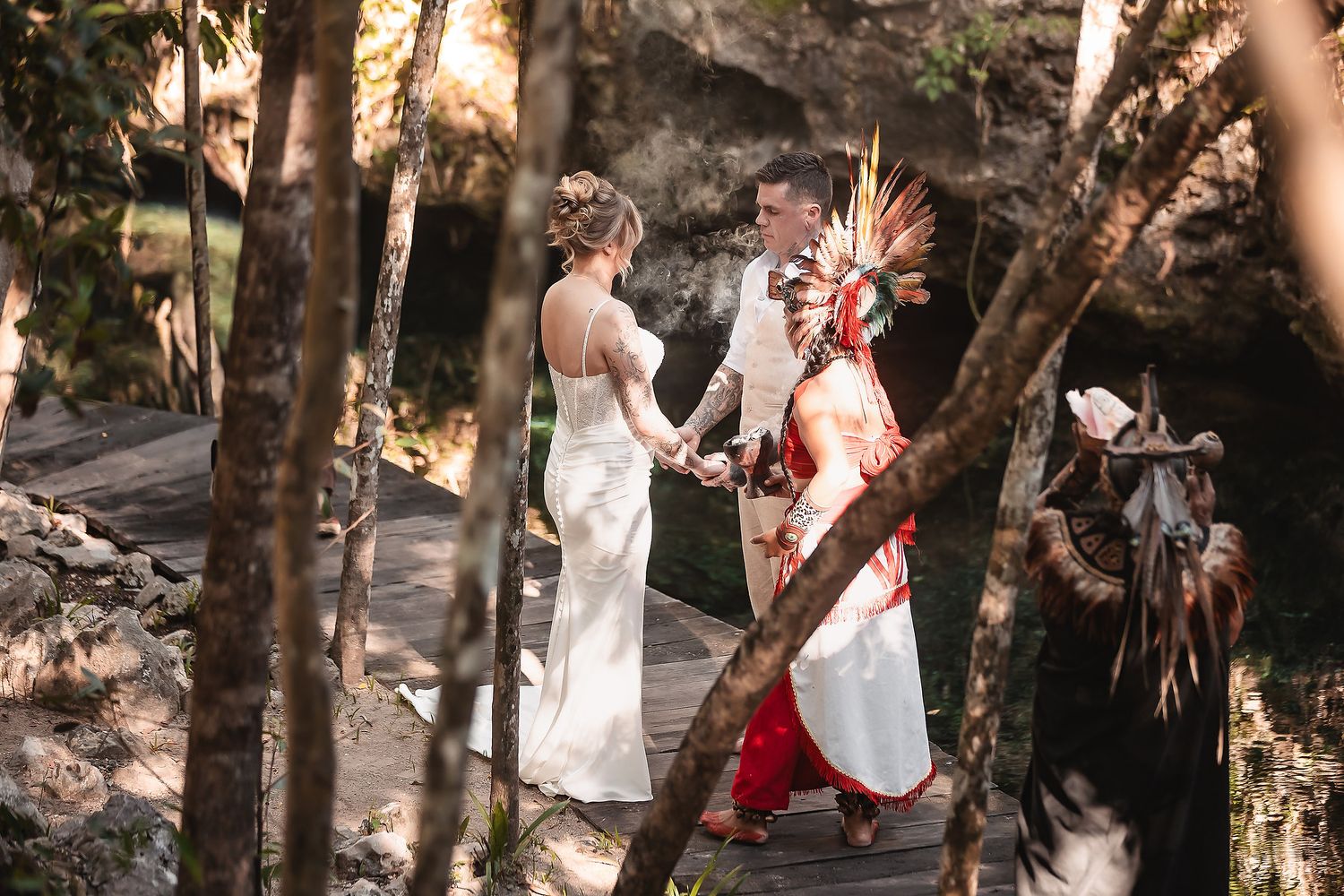 A wedding ceremony in a forest setting with traditional ceremonial decorations.