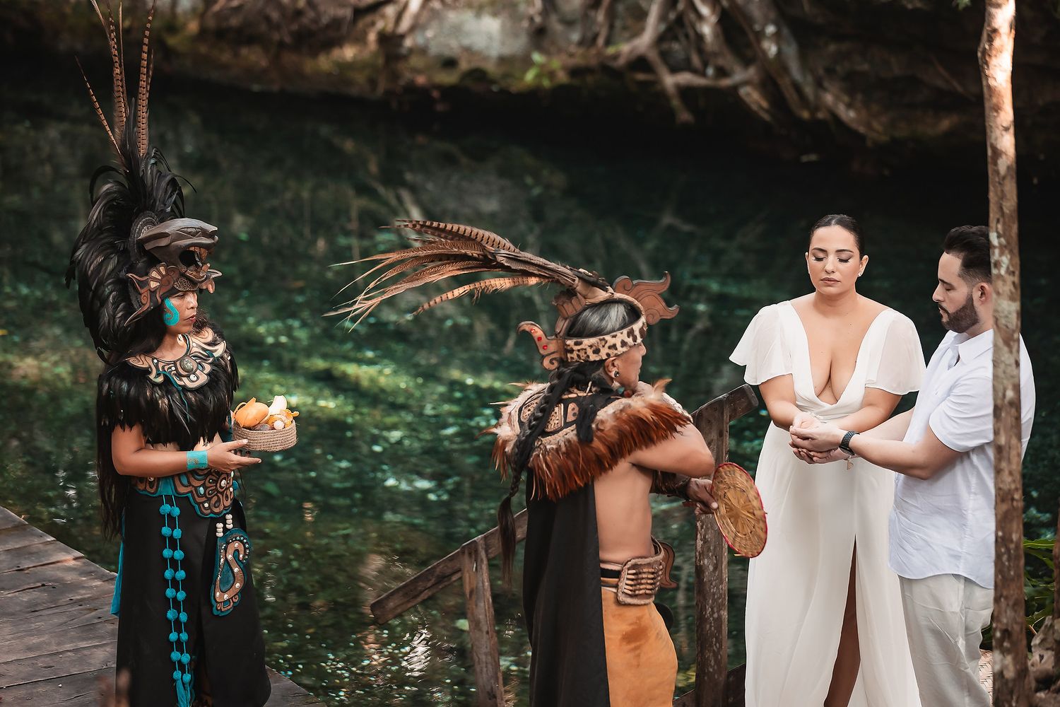 Mayan spiritual leaders in traditional dress performing ceremonial blessings by a cenote.