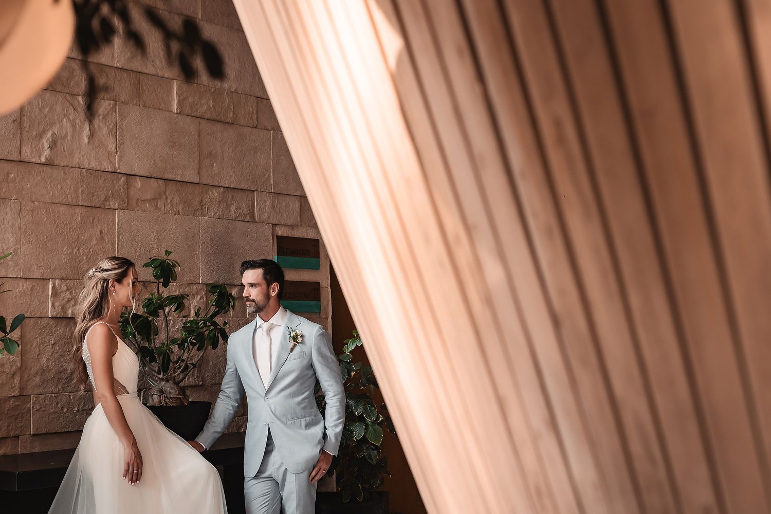 A romantic garden scene with tropical plants framing a couple's special moment.