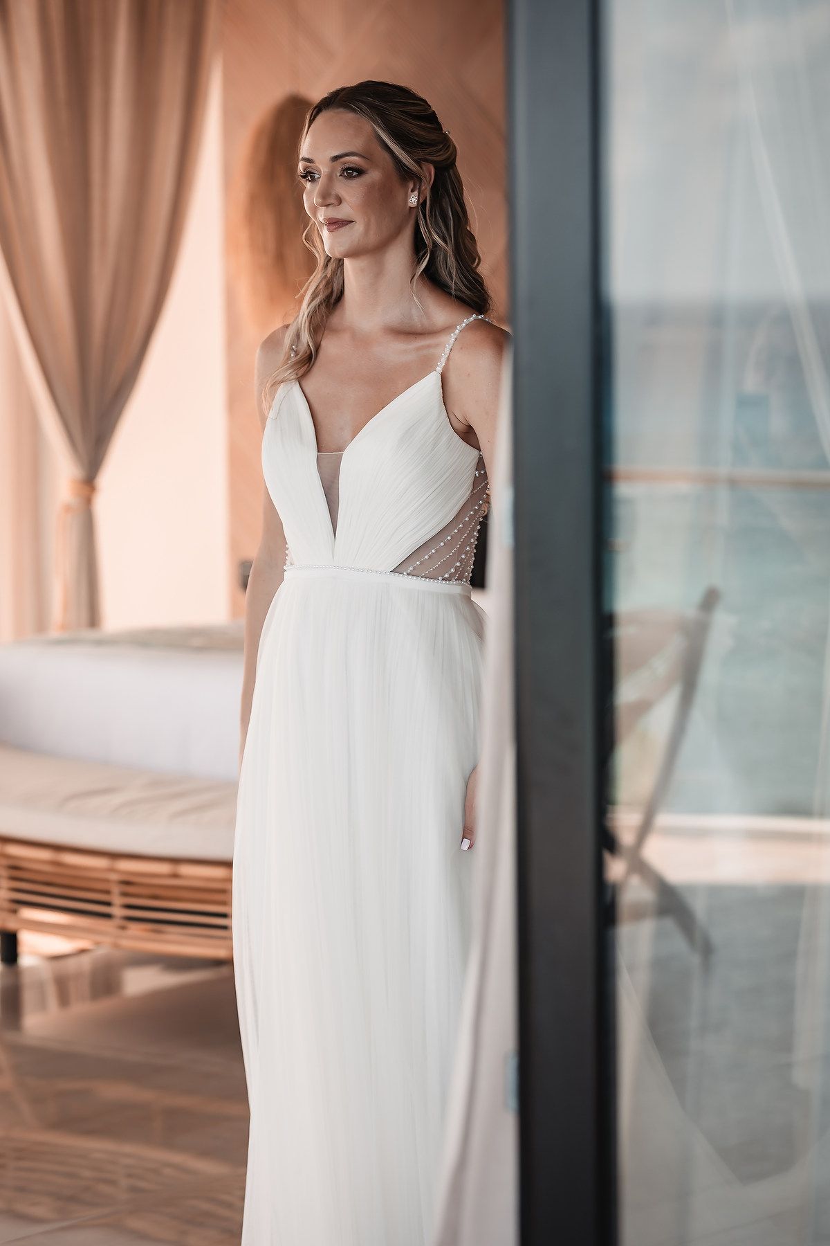 Elegant white wedding dress with delicate straps and modern design details.