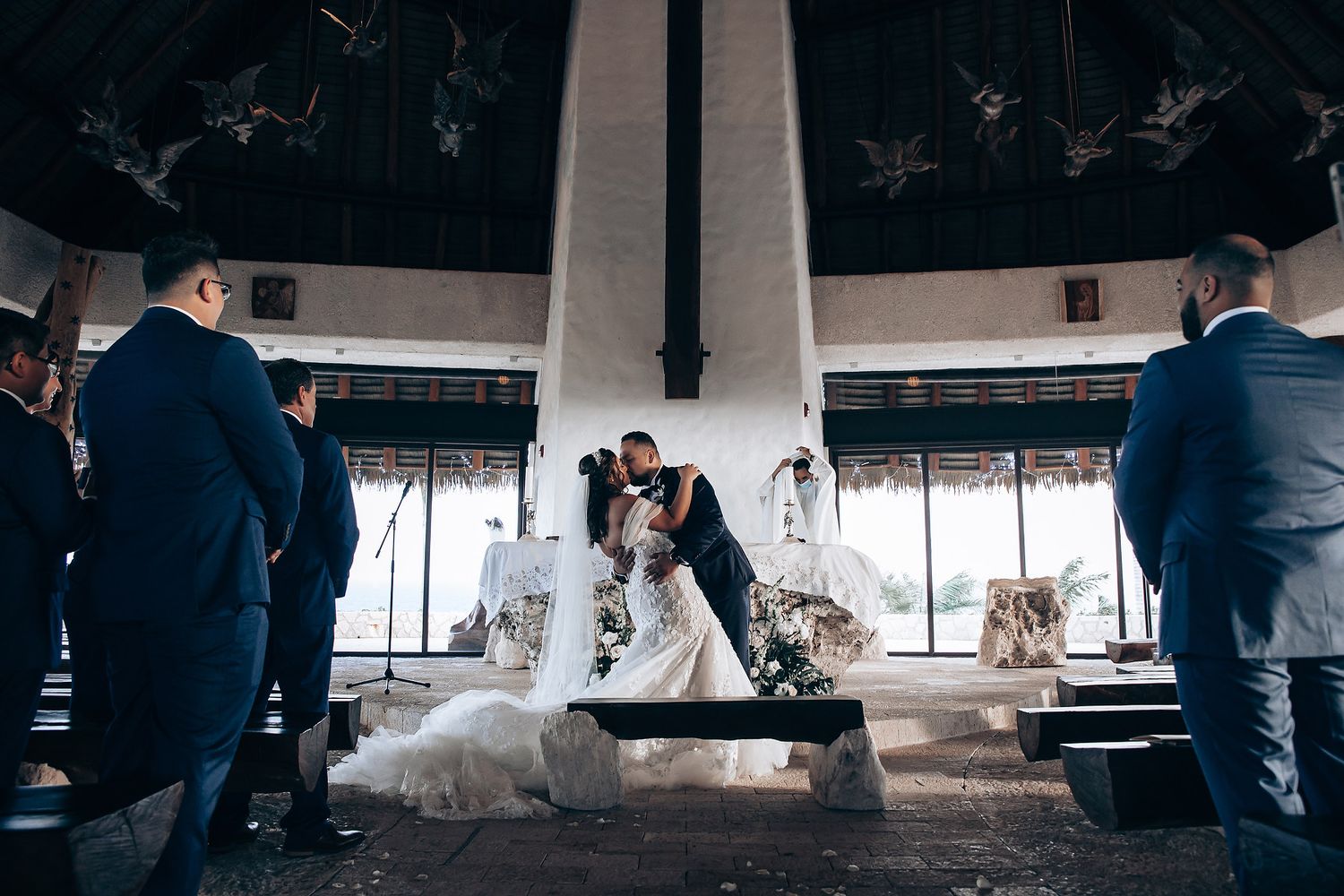Wedding reception venue with guests mingling under a covered outdoor space.