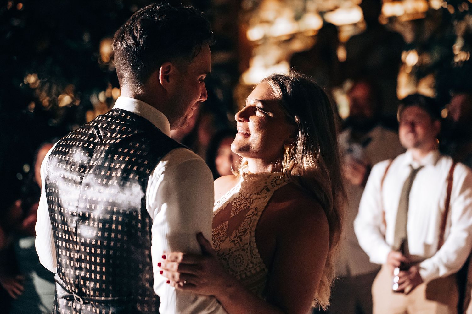 Couple shares an intimate dance moment at a dimly lit wedding reception with a disco ball overhead.