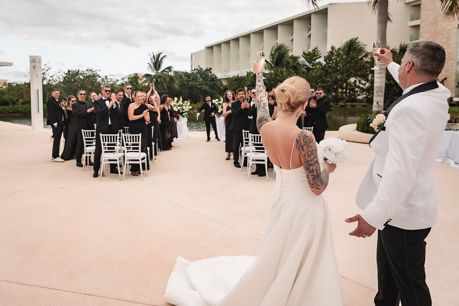 Wedding guests gather on an outdoor terrace for a celebration reception.