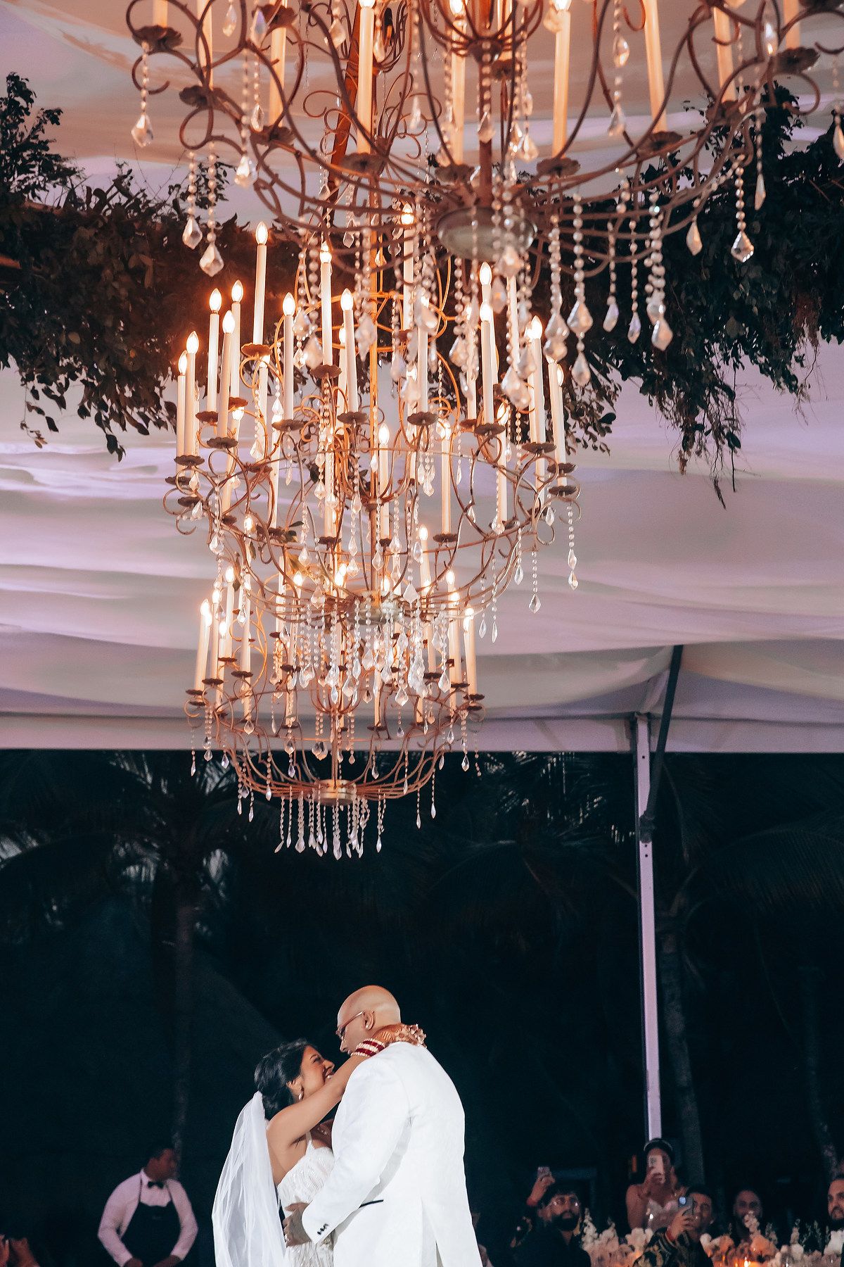 Elegant wedding reception venue with crystal chandeliers and draped fabric ceiling creating romantic ambiance.
