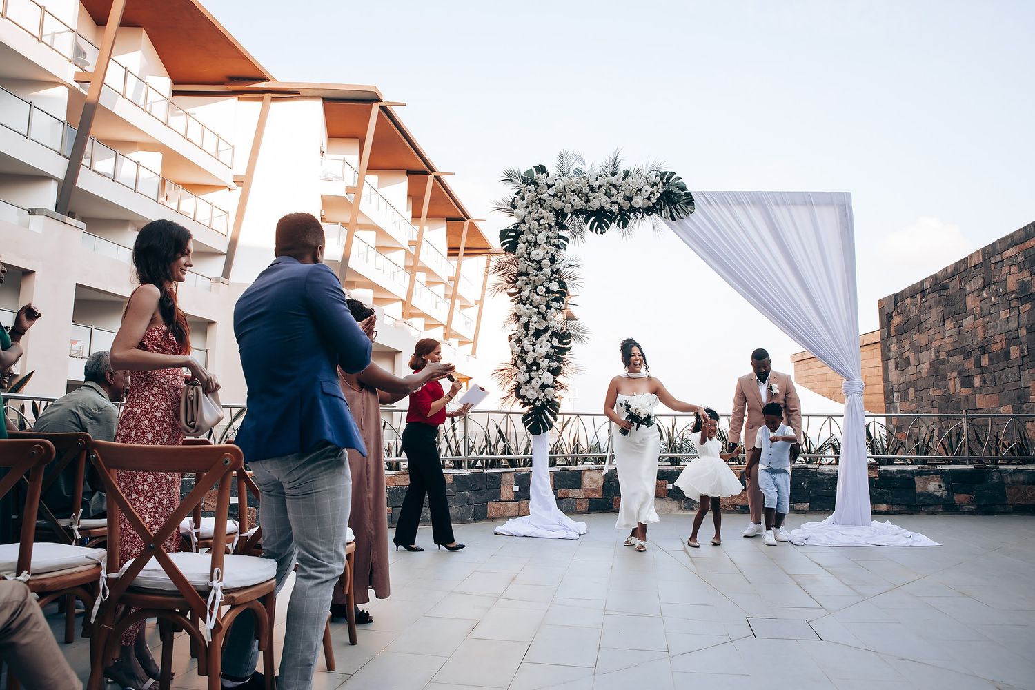 Panoramic view of wedding guests enjoying an outdoor celebration with mountain backdrop.