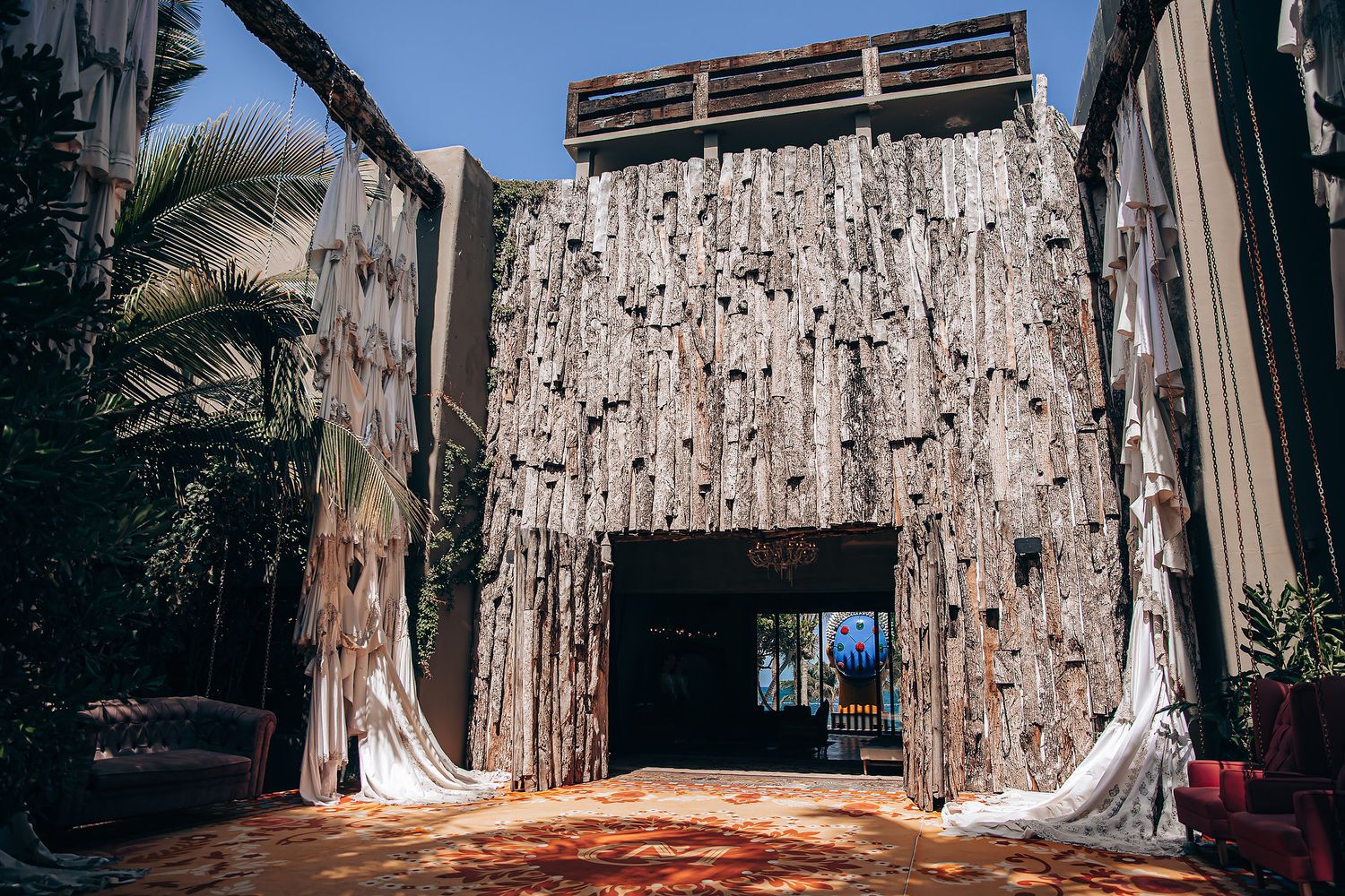 Rustic wooden wall backdrop with vintage decor and draped fabric creates a romantic outdoor photography setting.