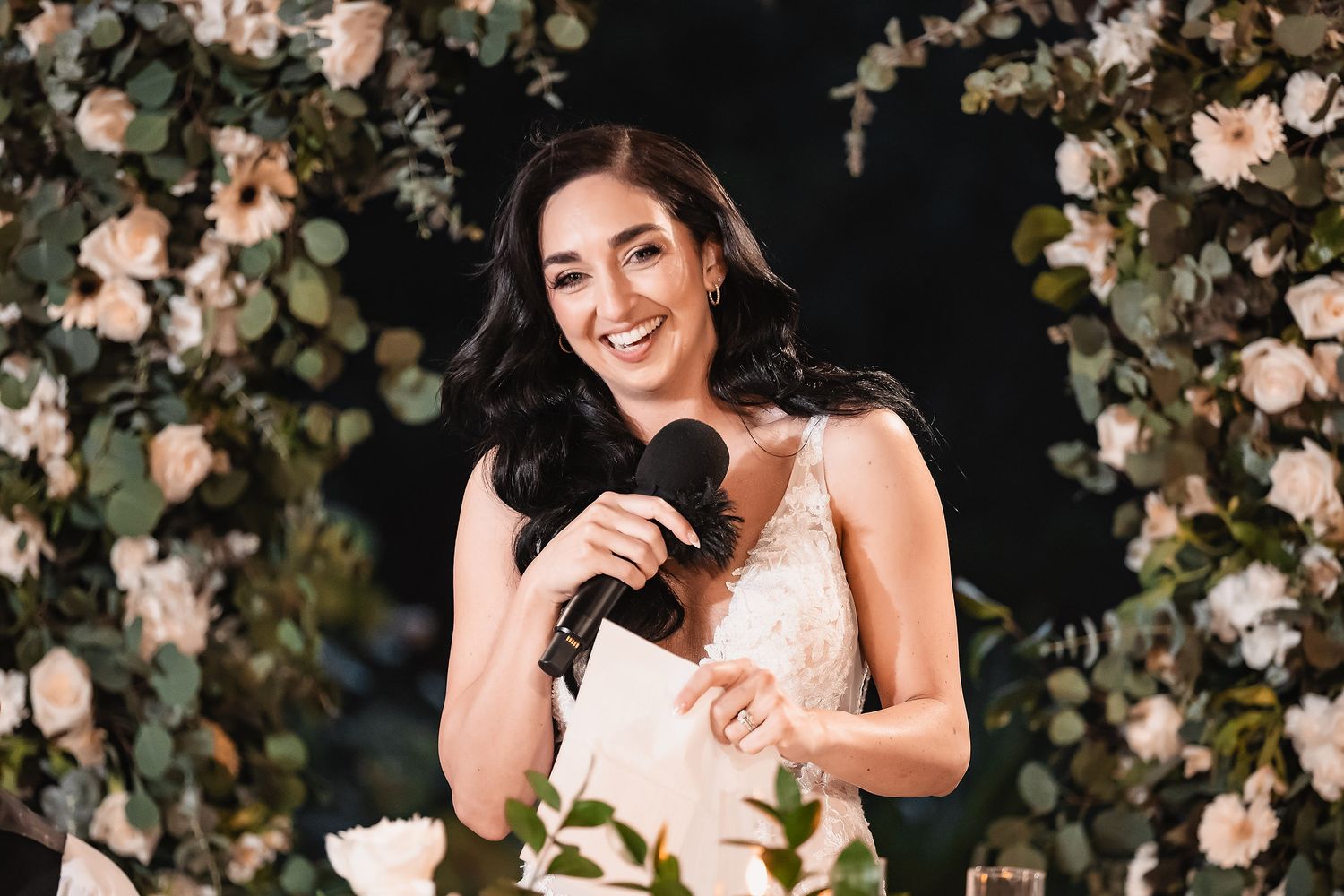 Elegant floral arch with pink and white roses creates a romantic backdrop.