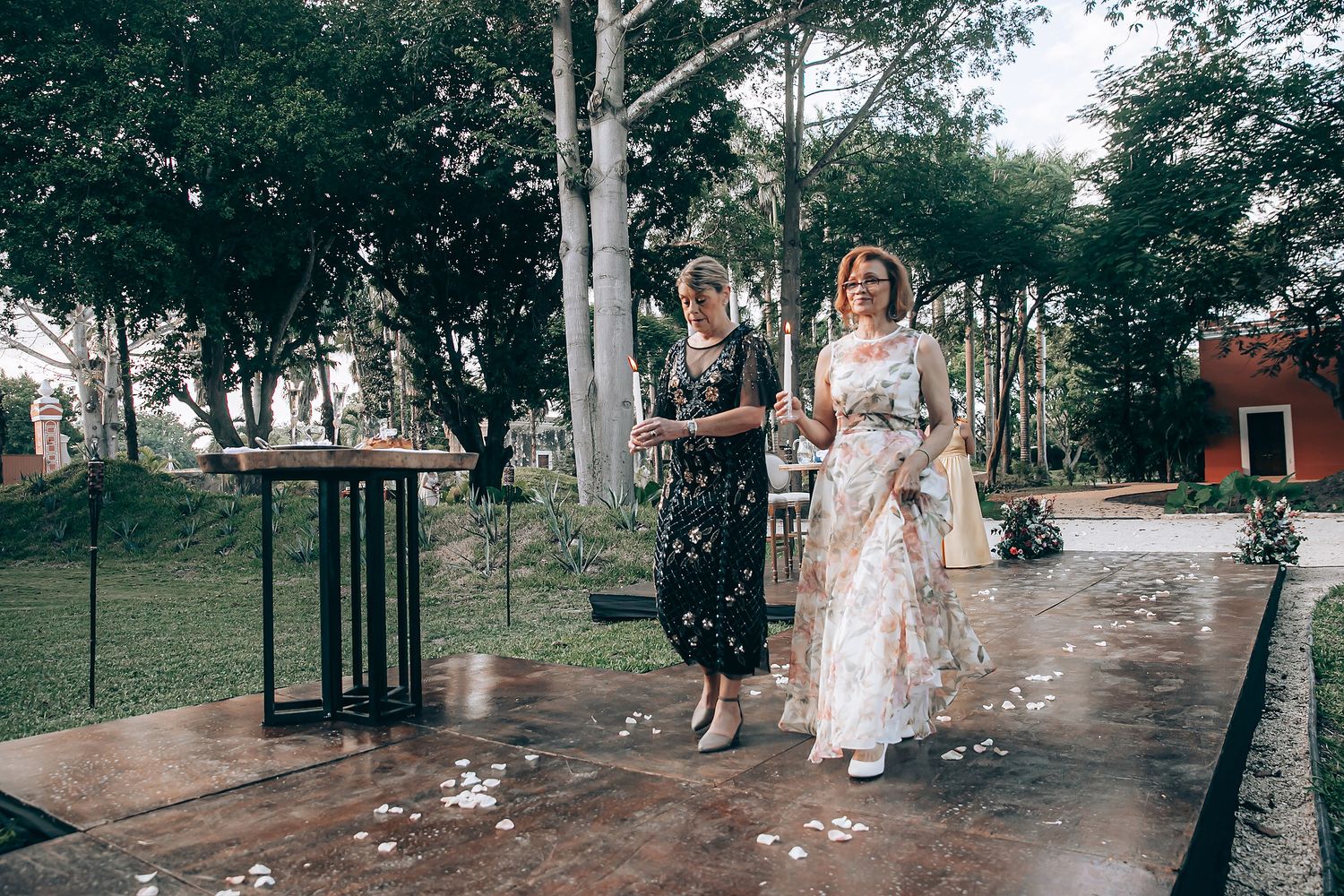 A joyful celebration scene with confetti flying in the air as people gather in a tree-lined outdoor setting.