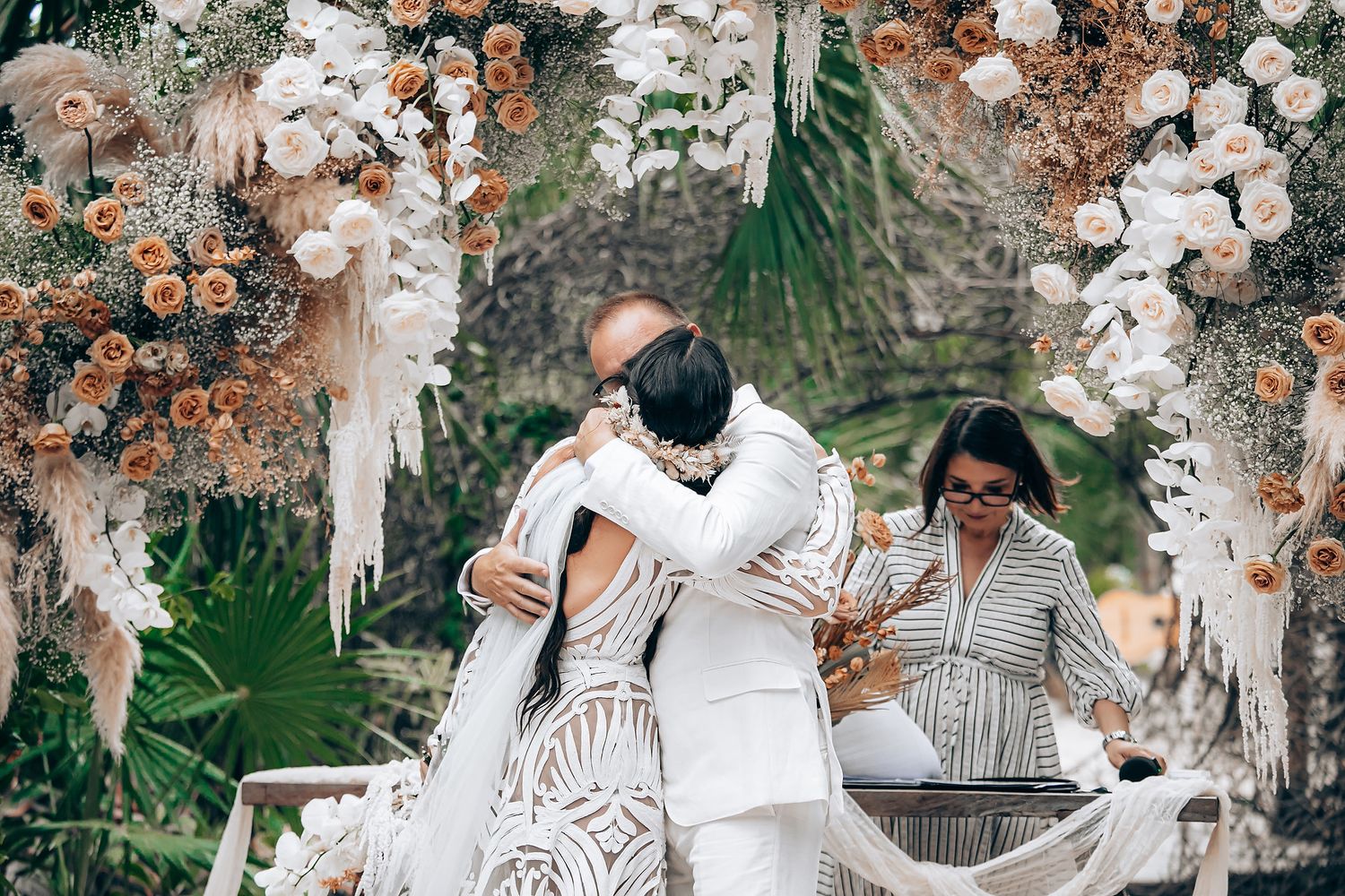Wedding guests celebrate joyfully with confetti and sparklers at an outdoor evening celebration.
