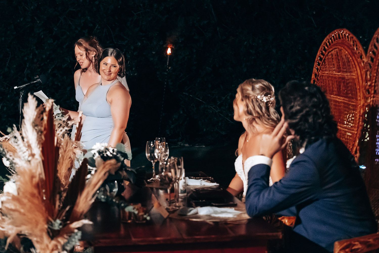 Intimate nighttime wedding reception with warm lighting and decorative elements.