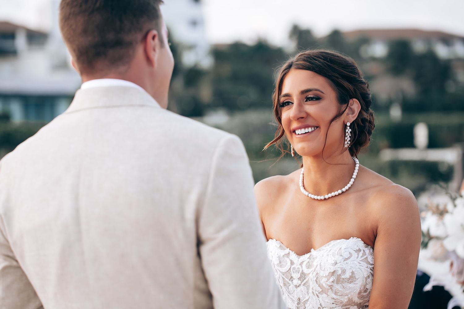 Romantic beachside wedding photoshoot with white wedding dress and tropical scenery.