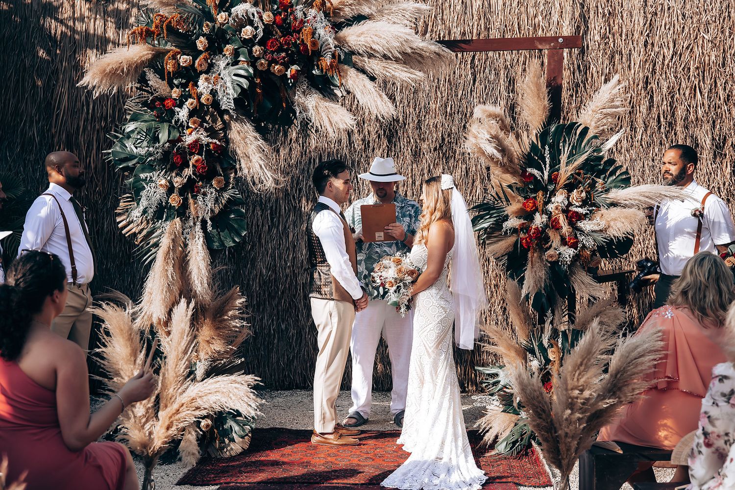 Festive wedding celebration with guests dancing under palm trees and string lights.