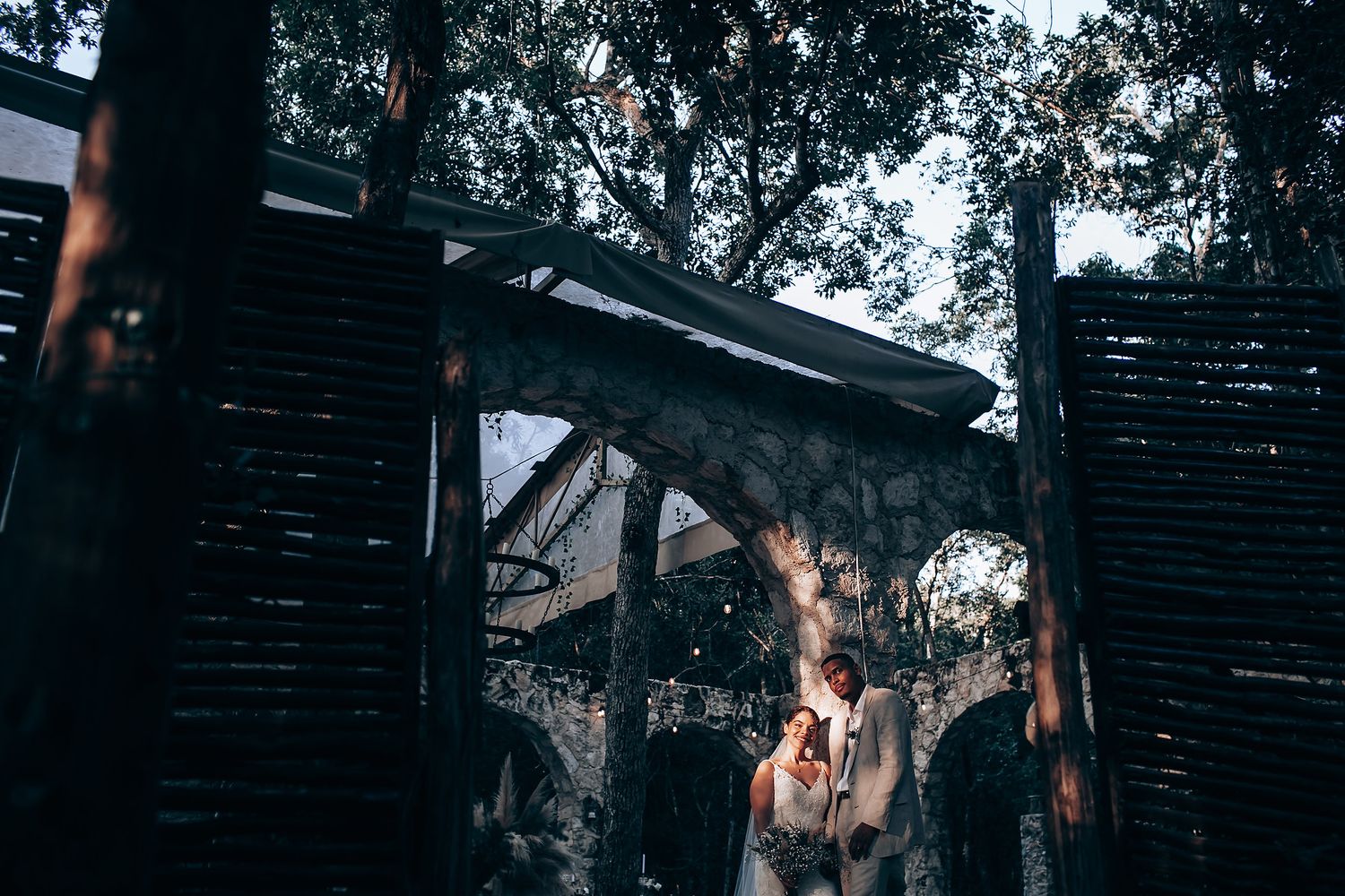 A series of artistic wedding photographs with dramatic backlighting in a forest environment.