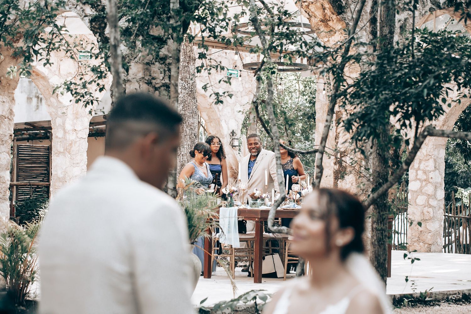 Wedding guests gathered in a woodland setting during an outdoor ceremony.