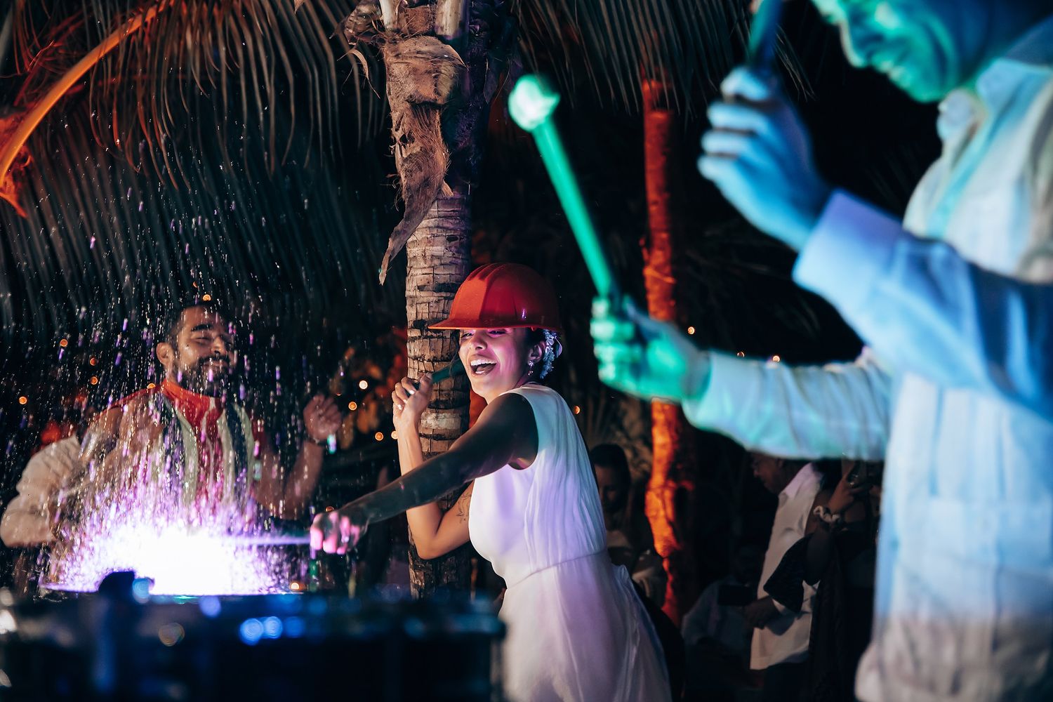 Colorful lights illuminate a lively dance floor as wedding guests celebrate in motion.