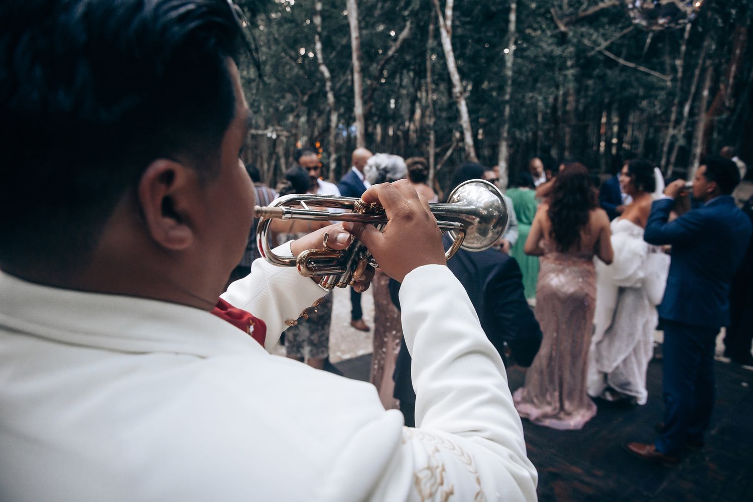 Wedding guests dancing and celebrating at an outdoor reception.