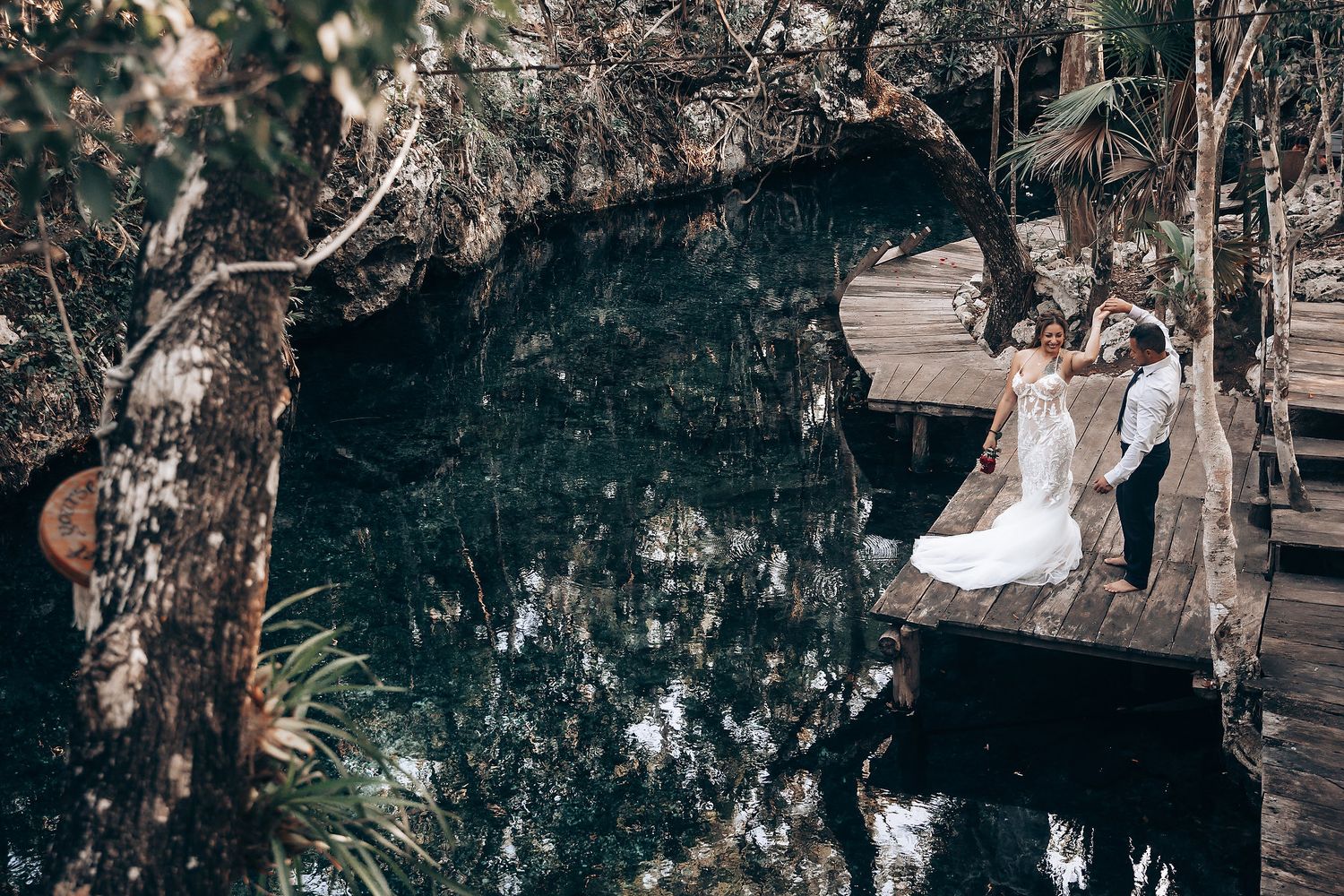A wedding celebration in a wooded area with decorative lights and natural elements.