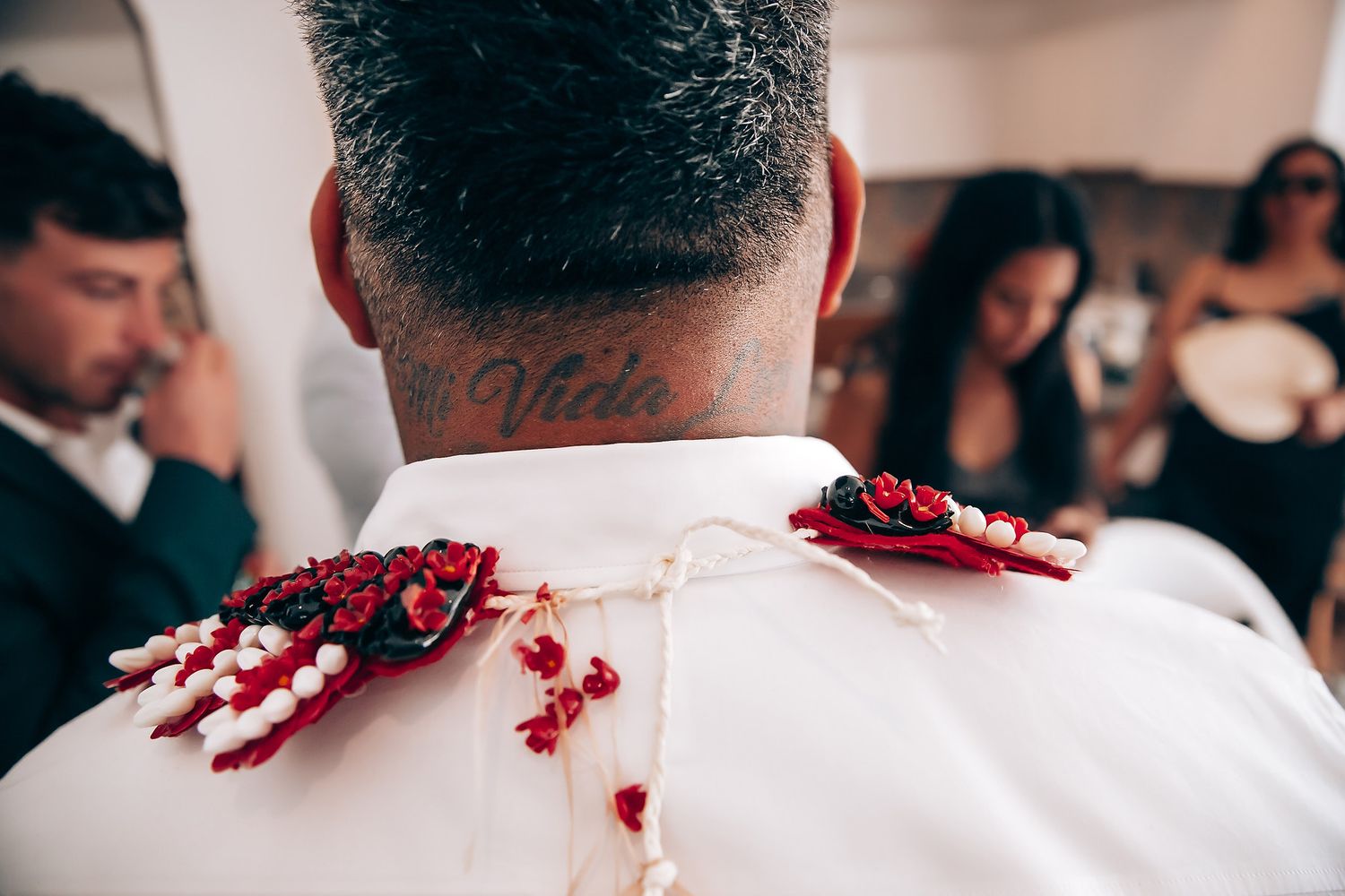 Wedding party members in formal attire with red floral accents.