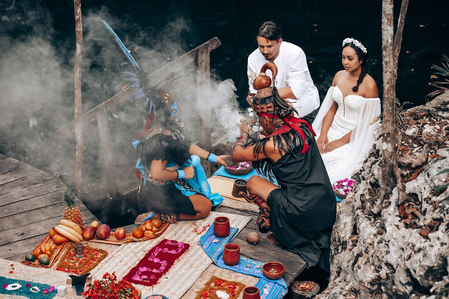 Traditional Hawaiian wedding ceremony taking place outdoors with cultural elements and ceremonial offerings.