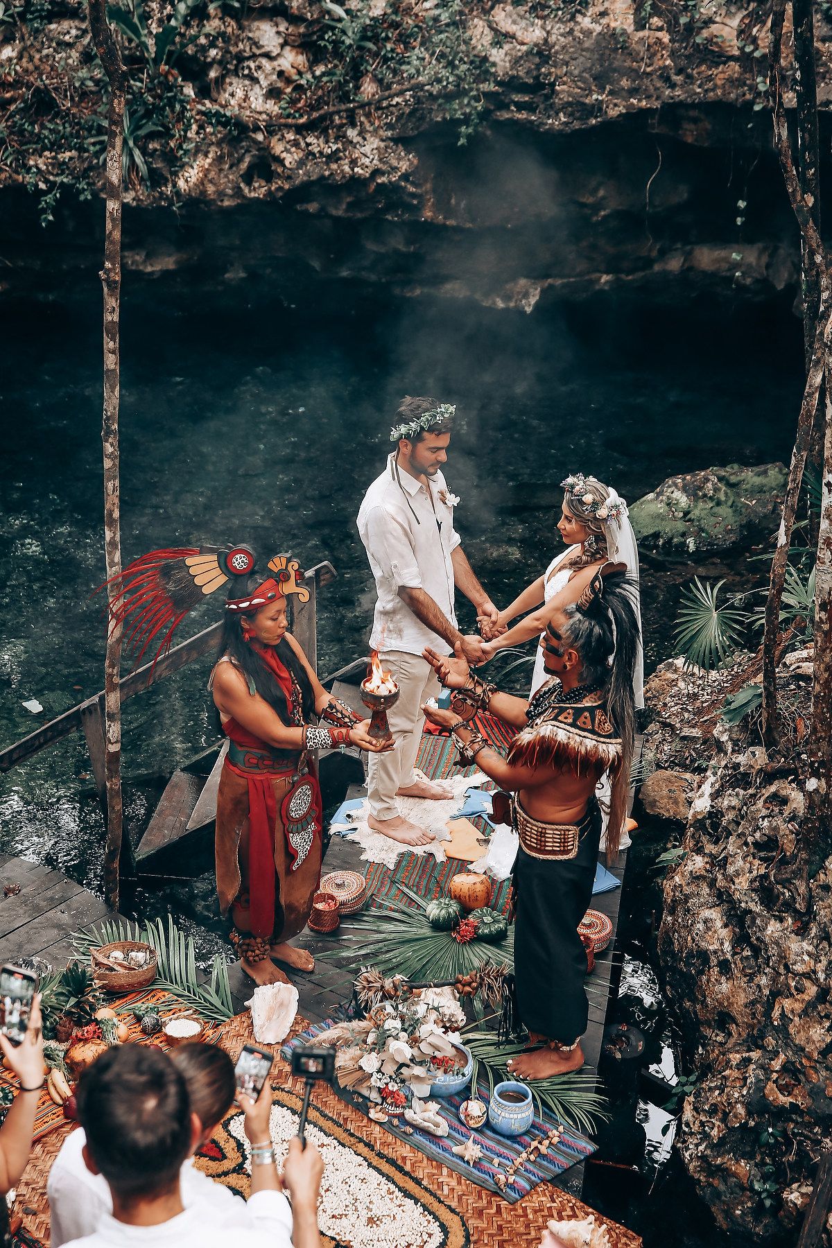 An indigenous-inspired wedding ceremony takes place in a mystical forest setting with traditional elements.