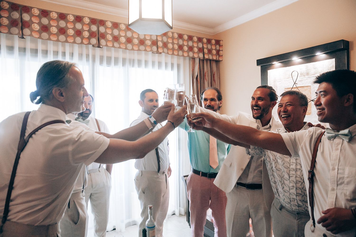 A group in formal attire toasting and celebrating together in a bright room.