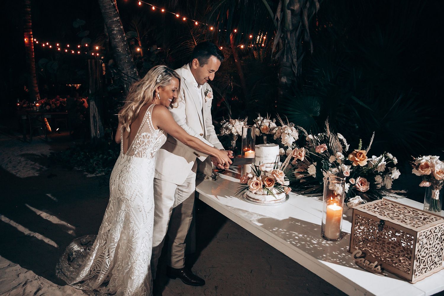 Wedding reception party with string lights and dancing guests in an outdoor evening setting.