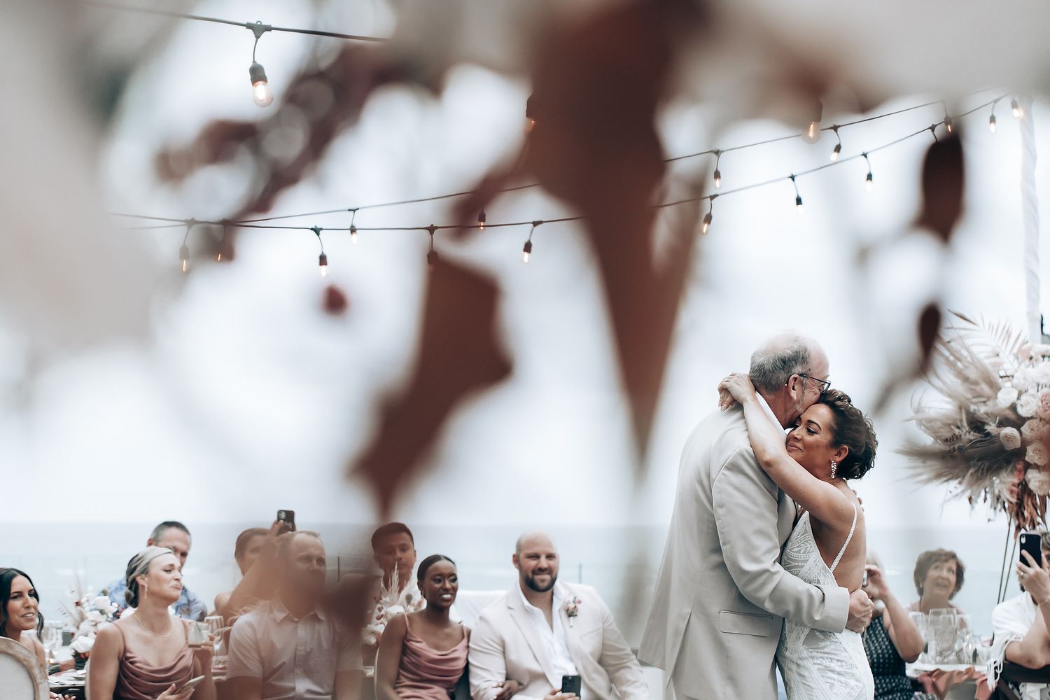 String lights create a dreamy atmosphere at an outdoor wedding reception.
