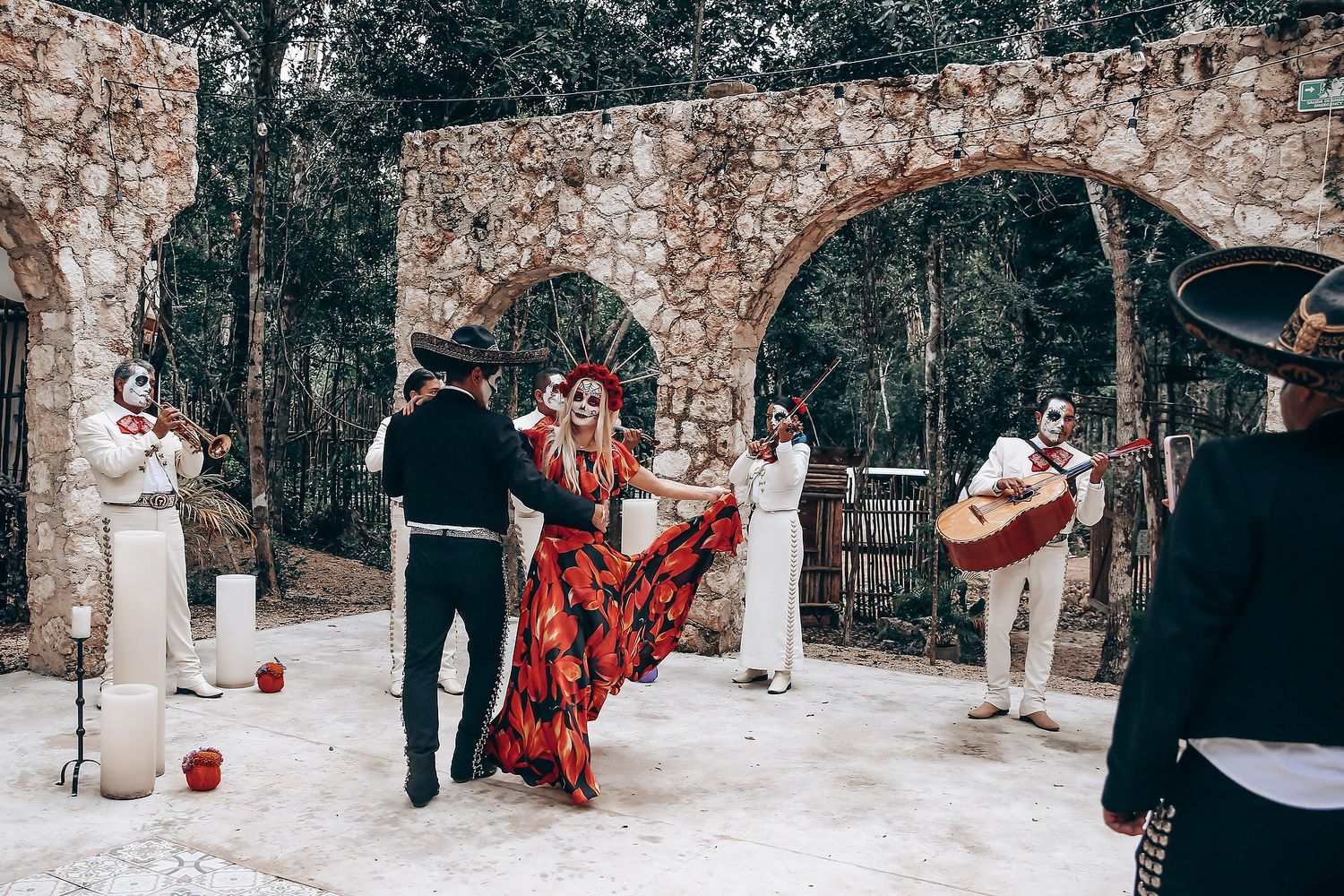 Day of the Dead celebration photoshoot with stone wall backdrop and traditional costumes.