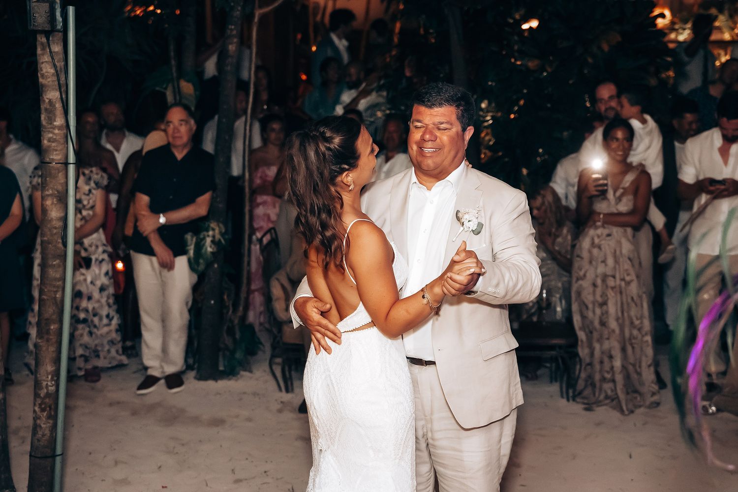 Wedding reception dance under evening sky with guests watching.