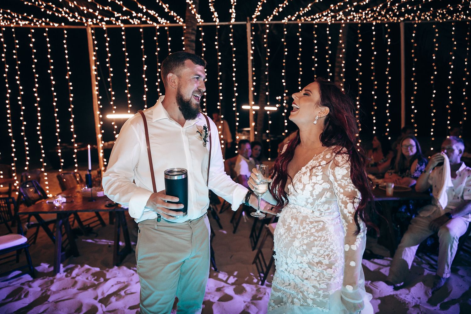 Couples dancing at a wedding reception under twinkling string lights creating a romantic atmosphere.