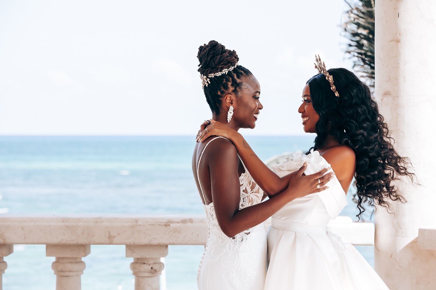 Couple in white wedding attire sharing intimate moments on a beachfront terrace.