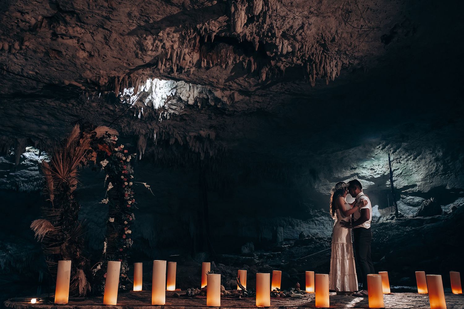 Dimly lit underground cave walkway illuminated by warm orange lights creating a mysterious atmosphere.