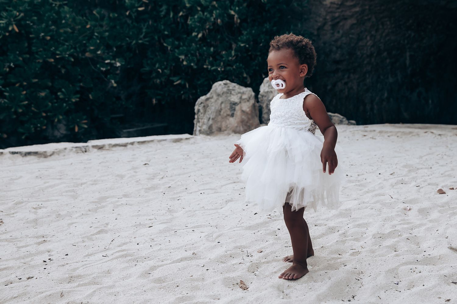 Children playing and running on a sandy beach during a wedding celebration.