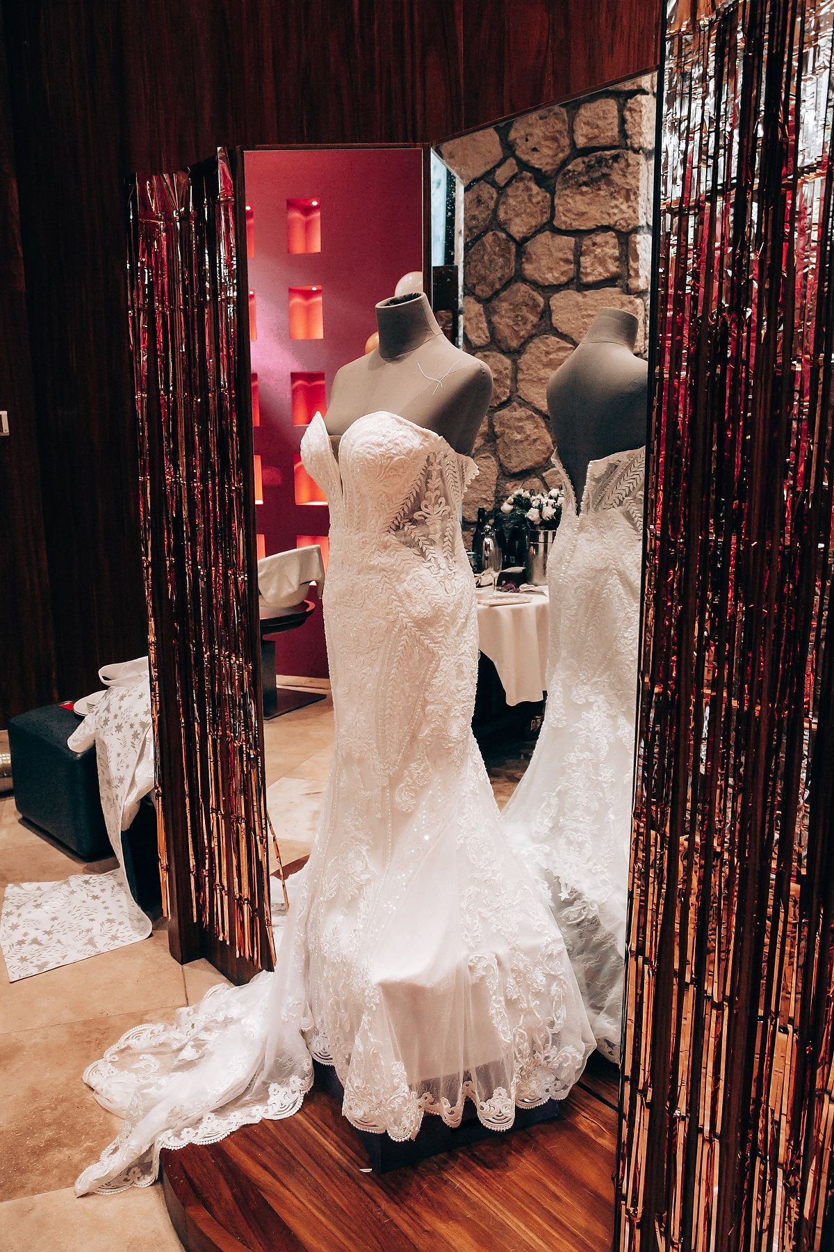 White lace wedding dresses on display with elegant black curtain draping in a bridal boutique.