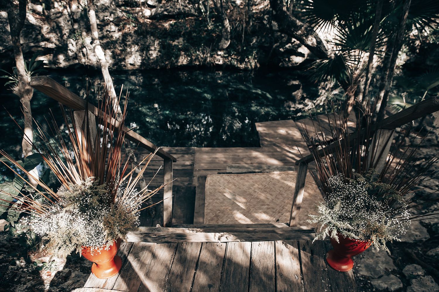 A wooden bridge surrounded by lush vegetation and trees in a serene forest setting.