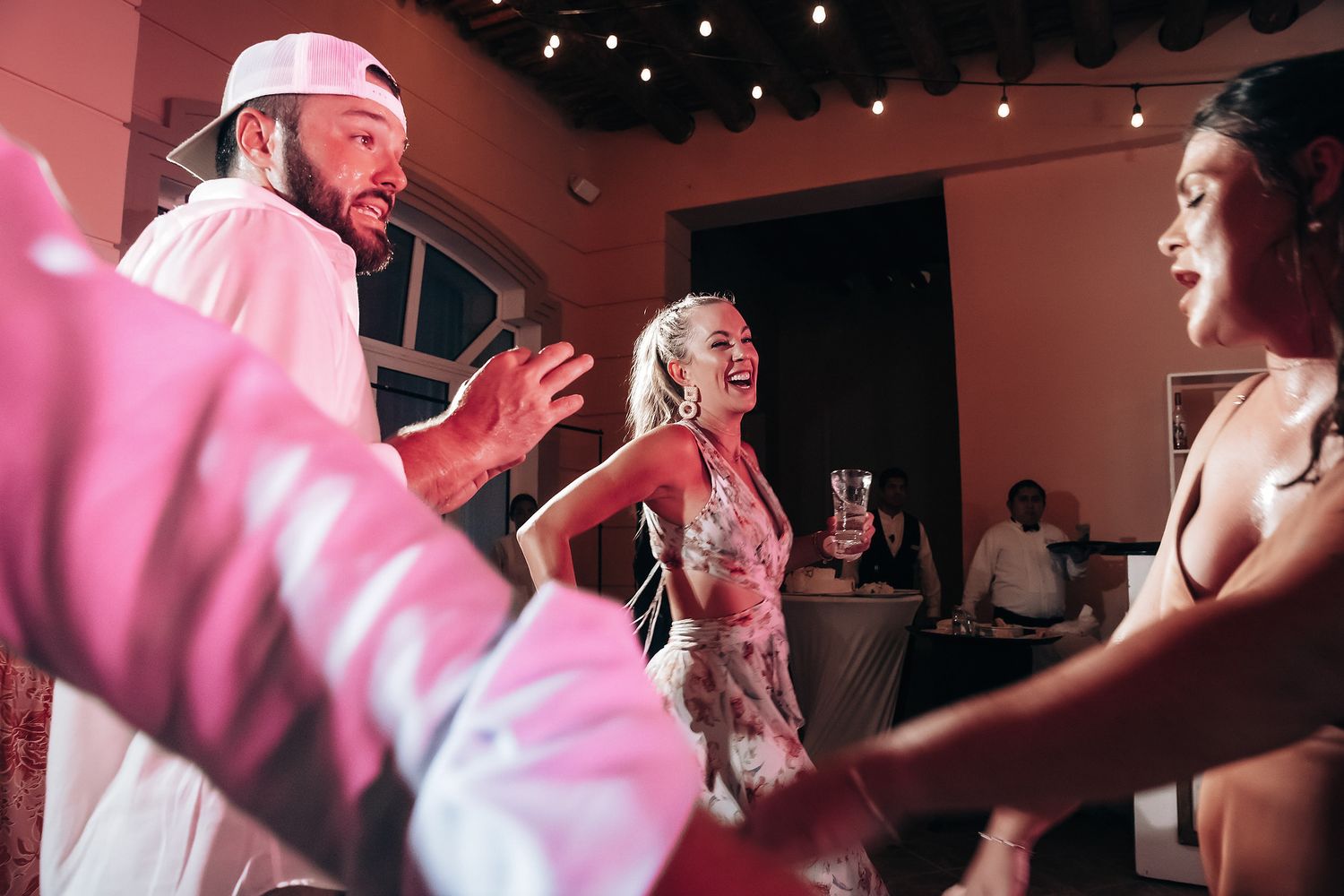 An image showing a group of people, including a couple, dancing and celebrating at what appears to be a party or event.