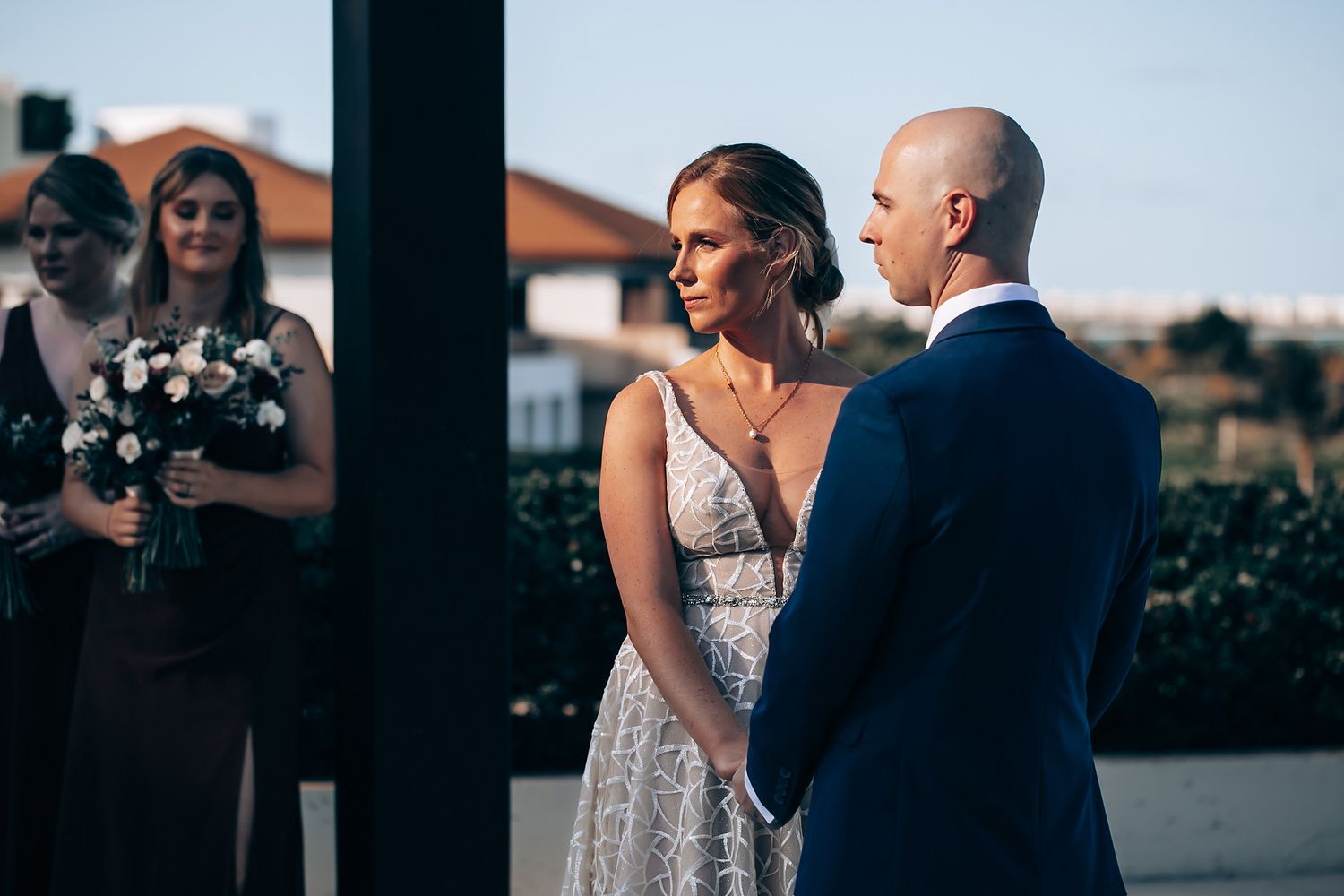 A bride and groom standing together and posing for a photograph at their wedding reception.