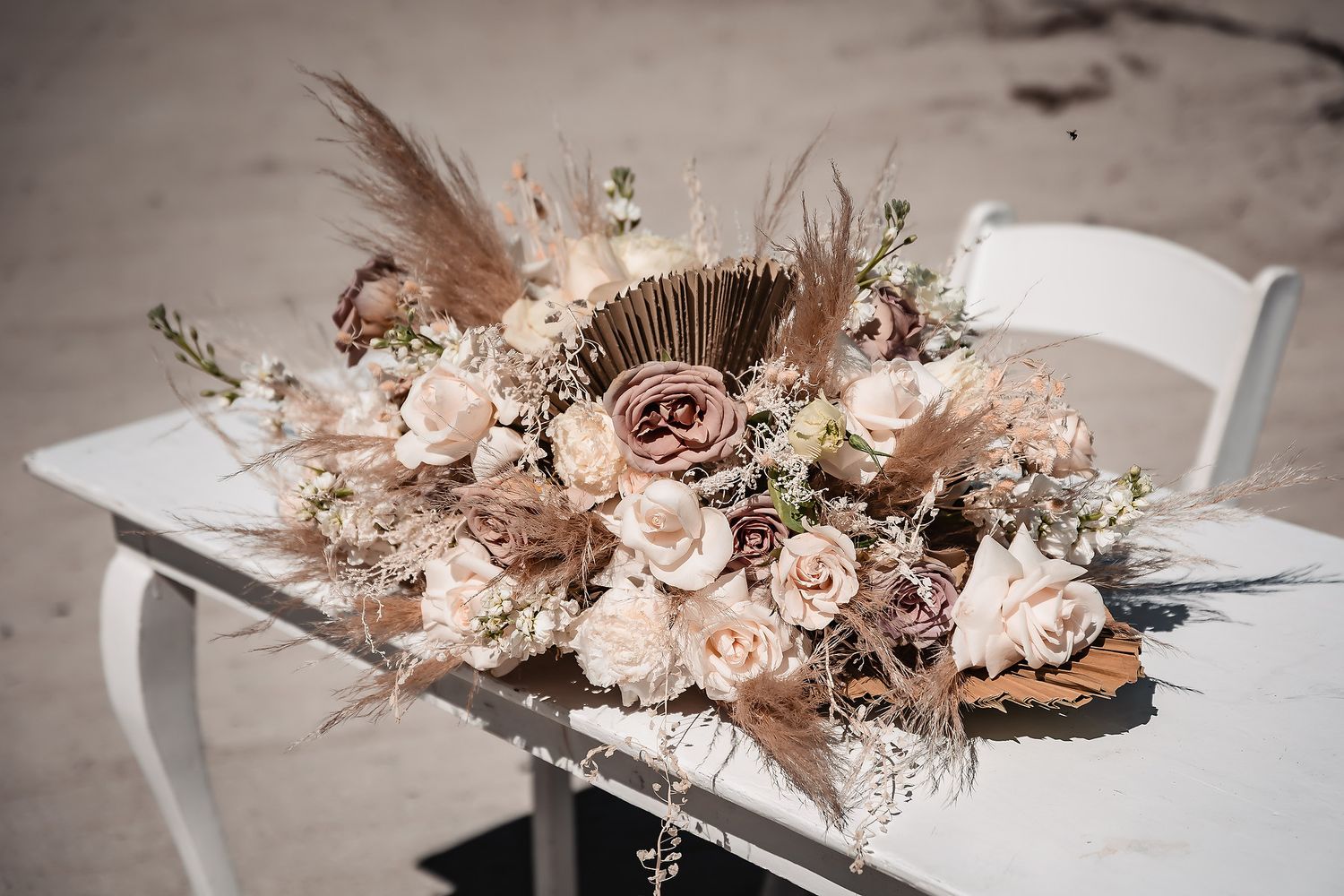 Delicate pink and white dried flower arrangement with roses and preserved botanicals in a modern vessel.