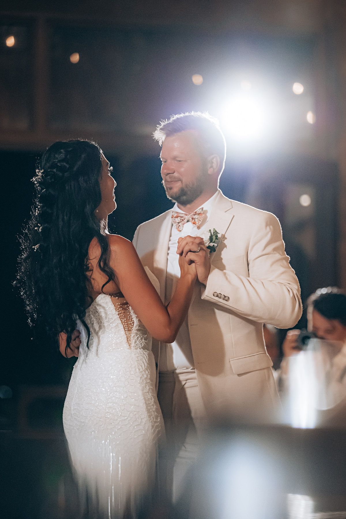 First dance moment captured in dramatic lighting at evening wedding reception.