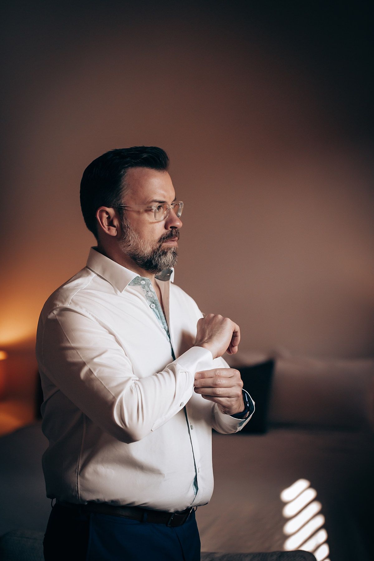 A sequence of photos showing a person in a white shirt lighting and smoking a cigar against a dark background.