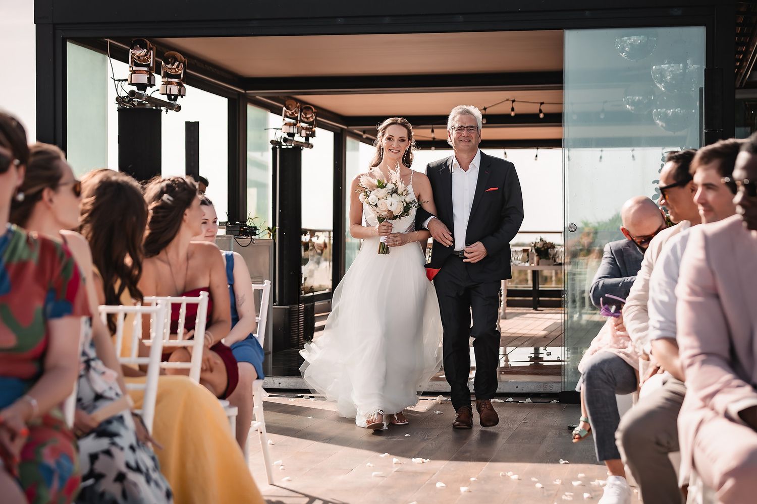 Wedding party members gather for candid moments at a beachside celebration.