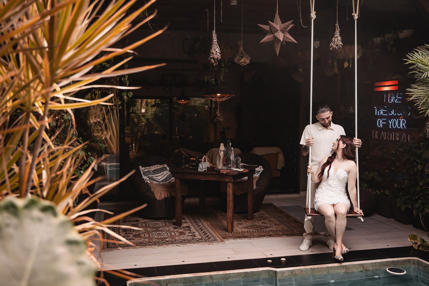 Outdoor evening celebration space with hanging star lights and natural palm fronds.