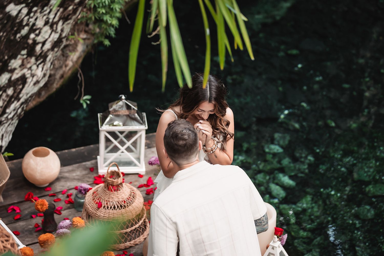 Couple sharing an intimate moment on a decorated outdoor patio with lanterns and cushions.
